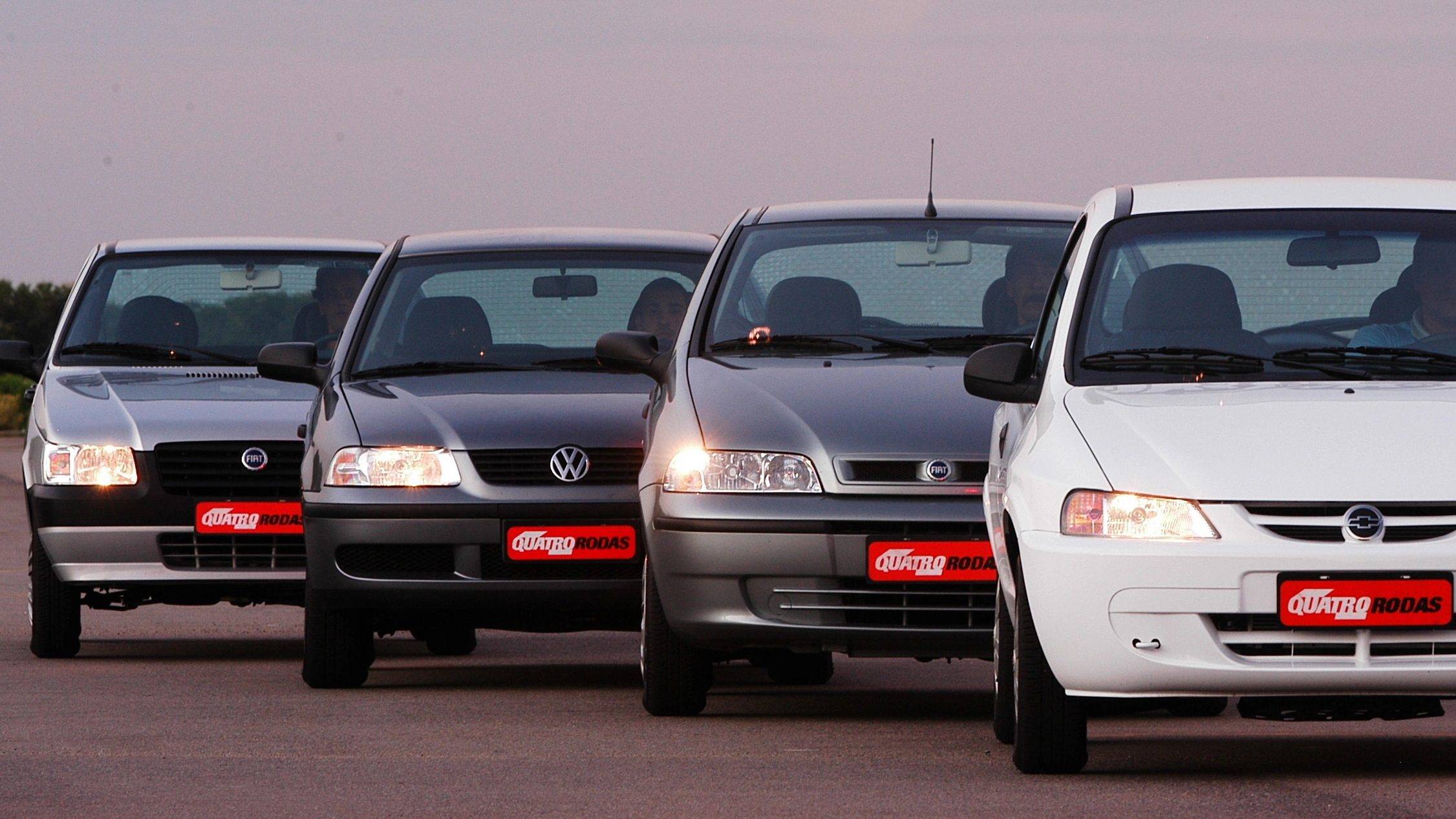 Carros populares antigos alinhados em uma pista