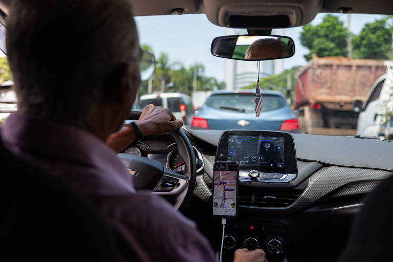 Motorista dirigindo com aplicativo de navegação no painel
